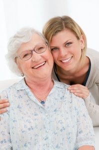 younger woman with hands on elderly woman's shoulders