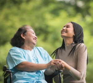 woman in wheelchair smiling with younger woman