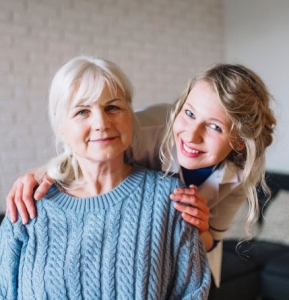 Woman sitting with nurse behind her