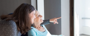 two women smiling as one points off to the distance